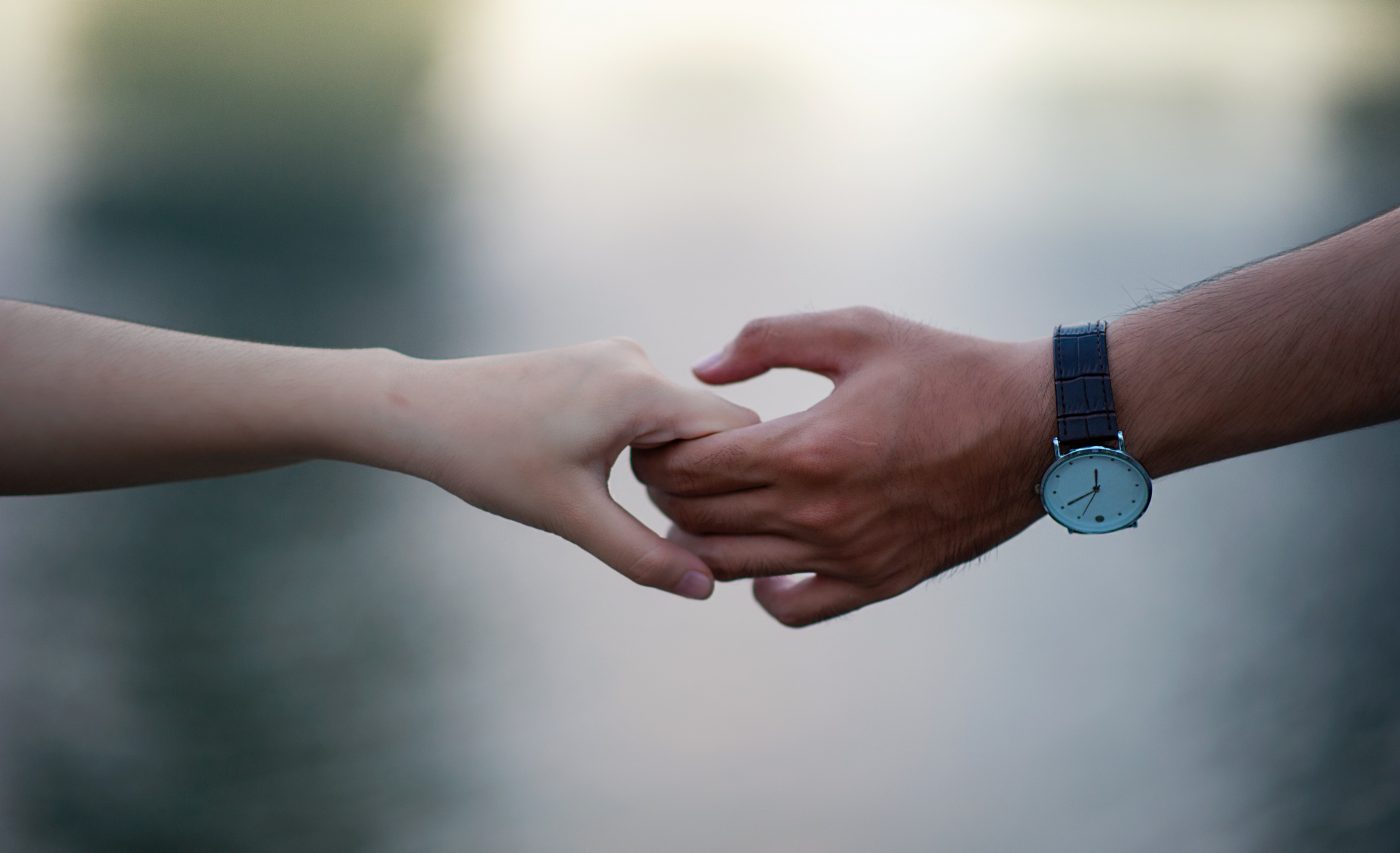 Hands reaching out to hold across soft background